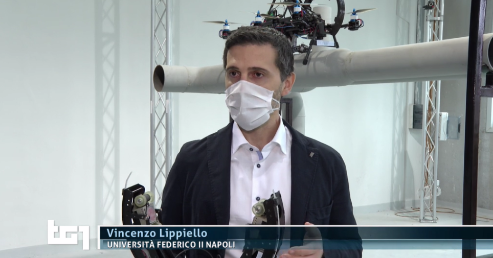 a frame from the video showing Prof. Vincenzo Lippiello holding the circular tool used by the hybrid robot to inspect the pipe